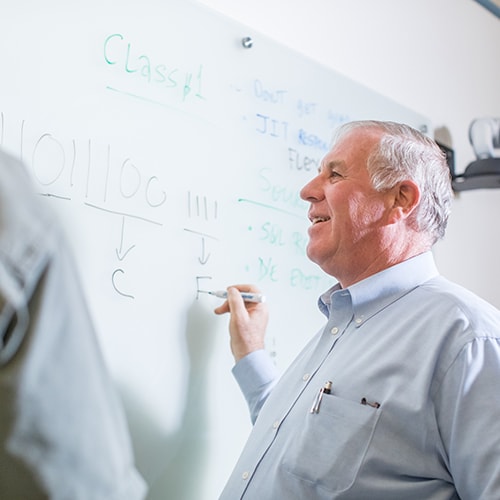 uma professor teaching at whiteboard