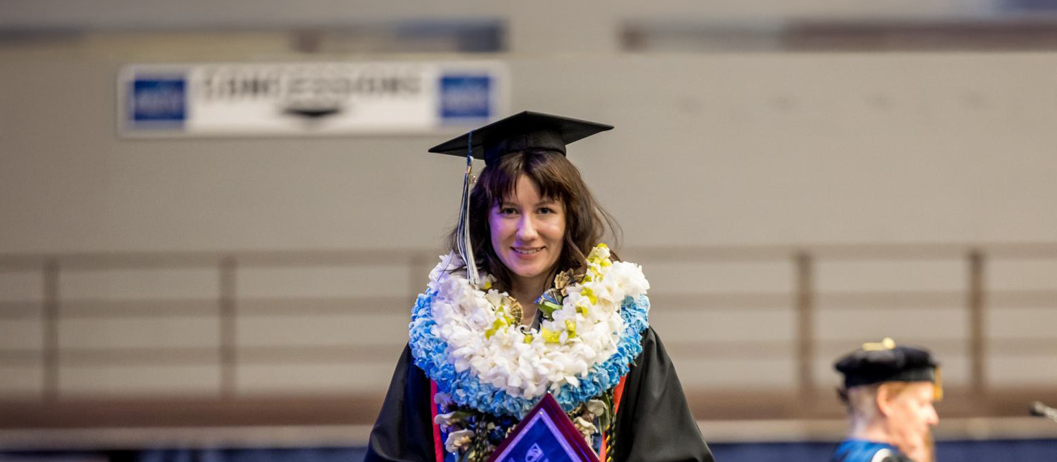 UMA ILS graduate walking the stage at Commencement