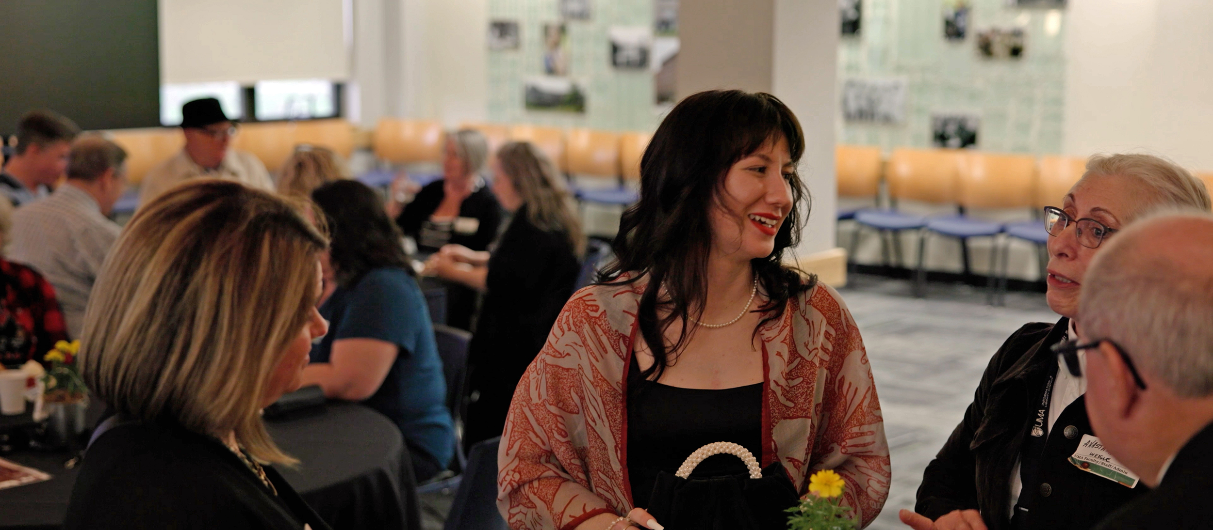 UMA ILS Grad in discussion with other UMA community members in the Frieside Lounge