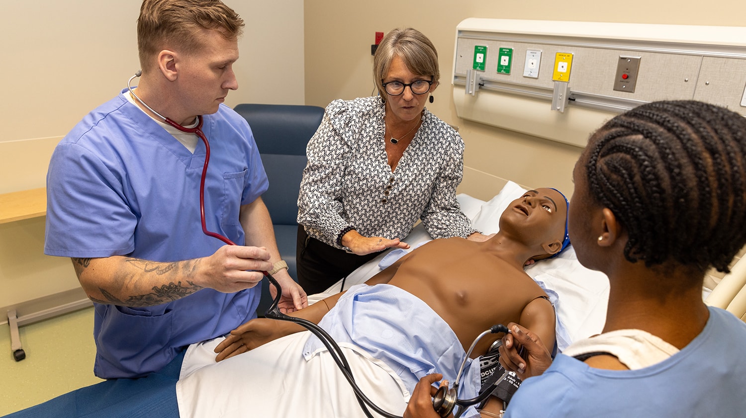 uma students and faculty member learning in sim lab
