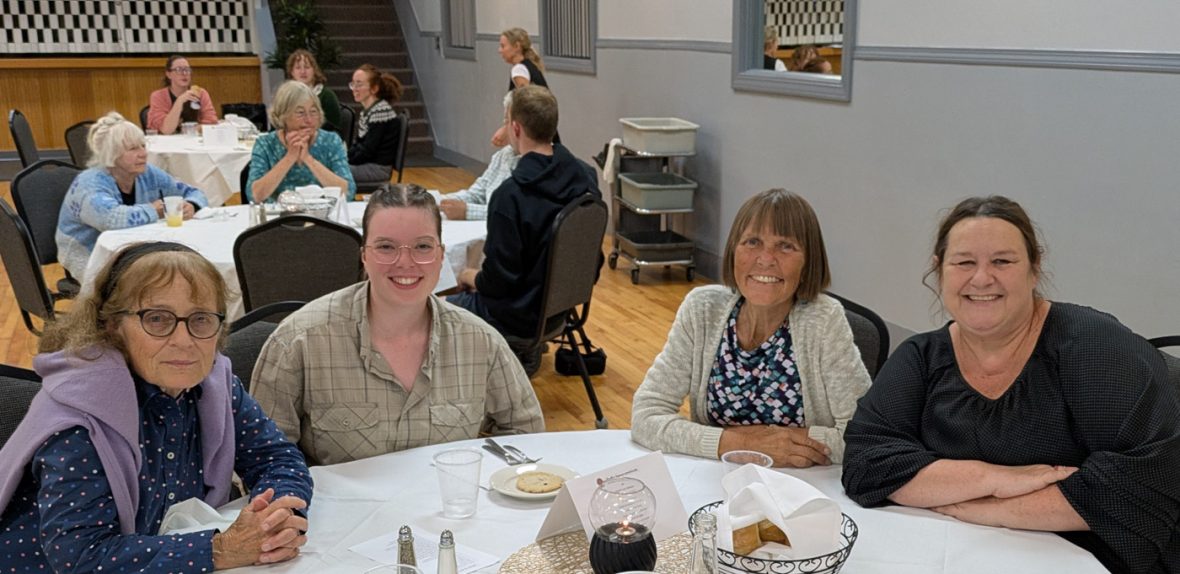 Two attendees seated at a banquet table, smiling for the camera.