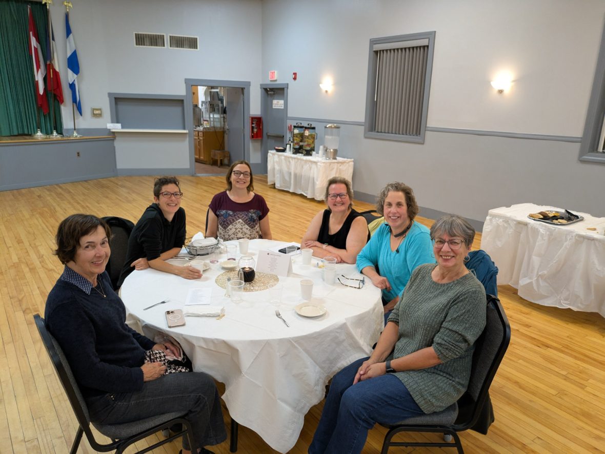 Six attendees seated around a banquet table