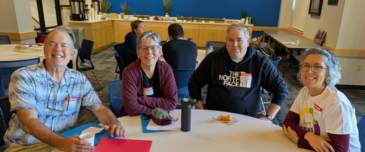 Four participants seated around a table during a French immersion program activity.