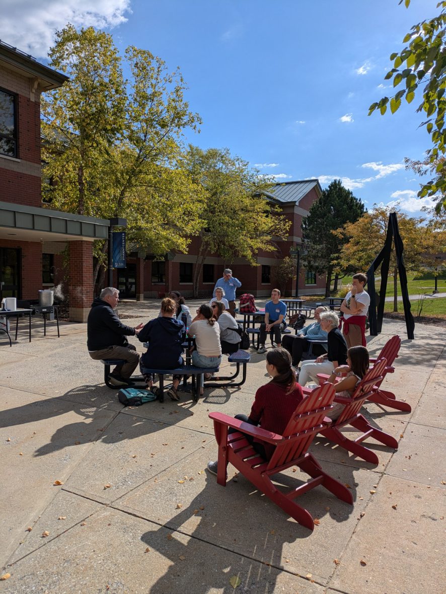 Participants gather outdoors for a discussion activity on campus.