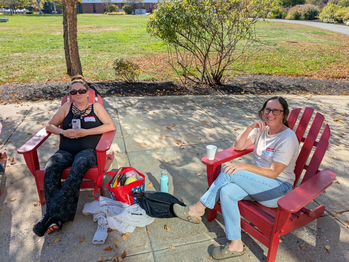 Two participants relax in Adirondack chairs outdoors during a break in the French immersion program.