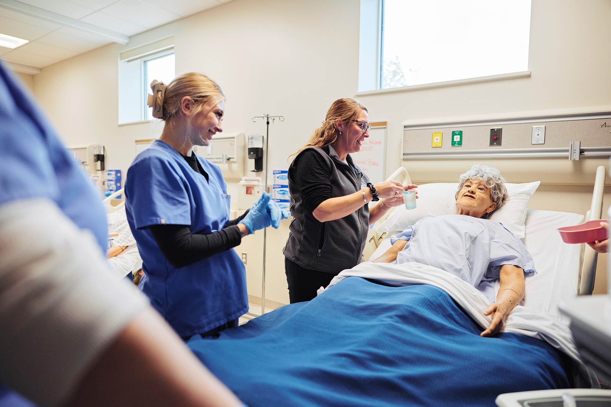 uma student watches faculty administer medication in sim lab