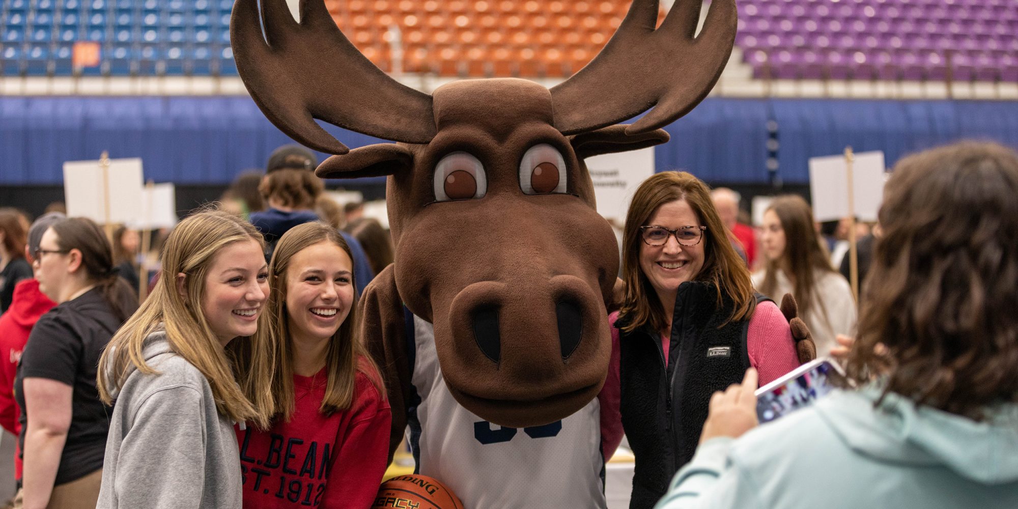 Augustus the Moose poses for a photo with local high school students at a college fair
