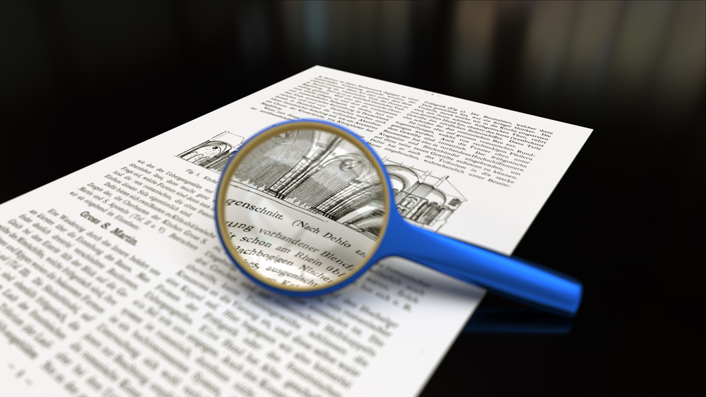 A magnifying glass on top of a printed page is focused on a paper.