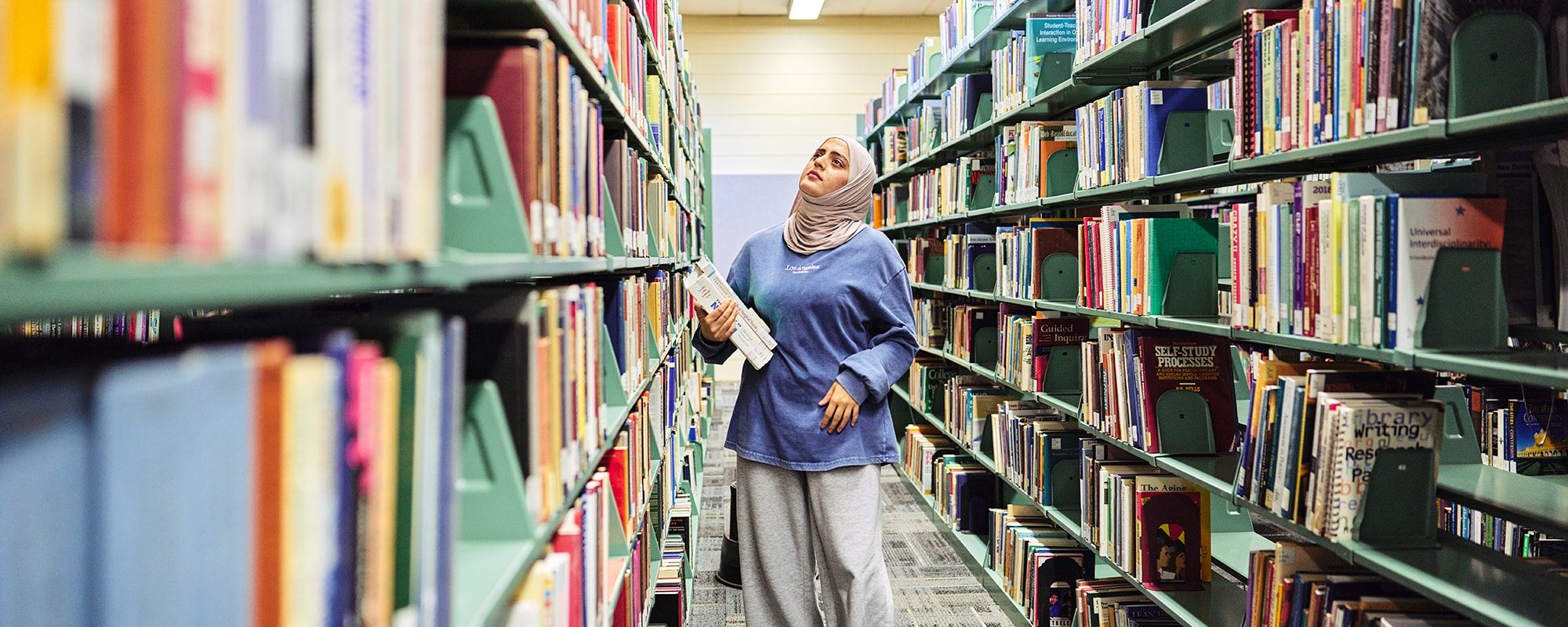 uma student in library stacks