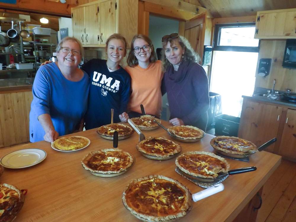 Participants posing with a row of pies at the French Immersion weekend.