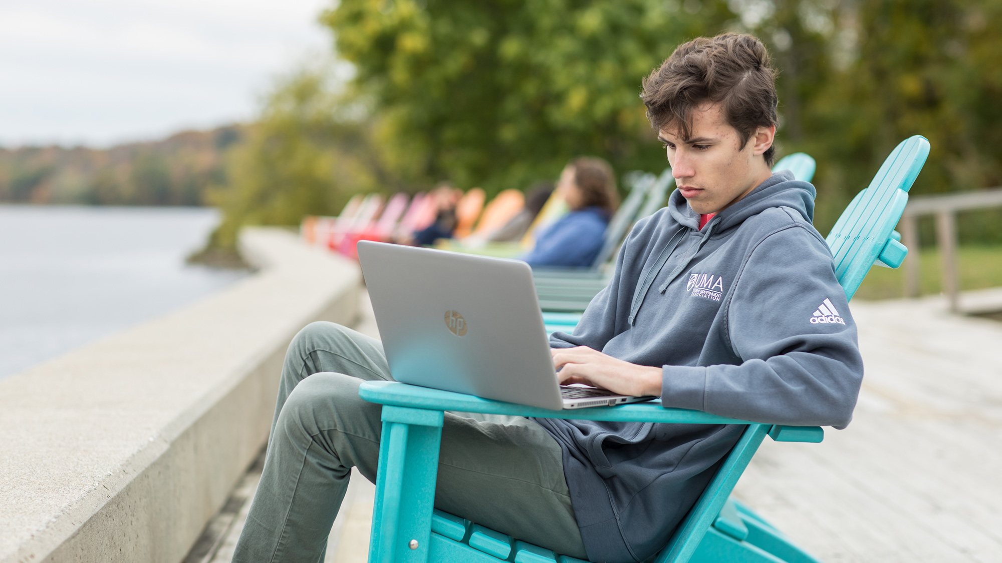 UMA Student on Laptop on the Riverside