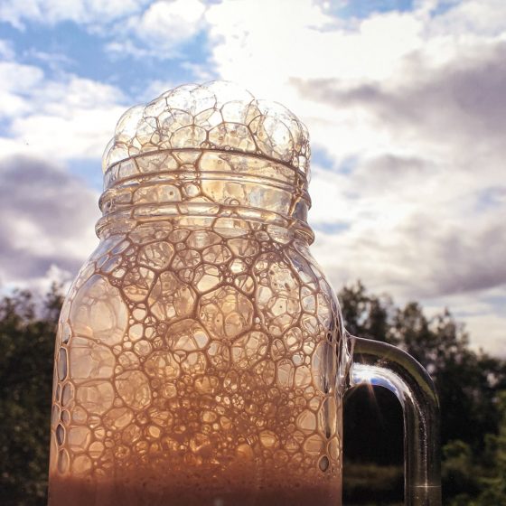 Photo of glass jar with liquid foaming through the top. Artist: Augrey Mclaughlin, "Bubbles", Cony High School