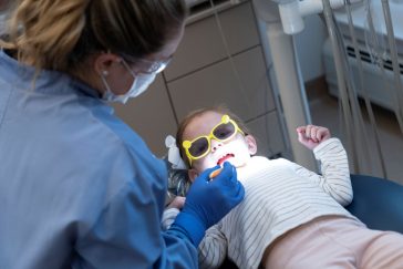 UMA Dental Assisting student cleans the teeth of a child.