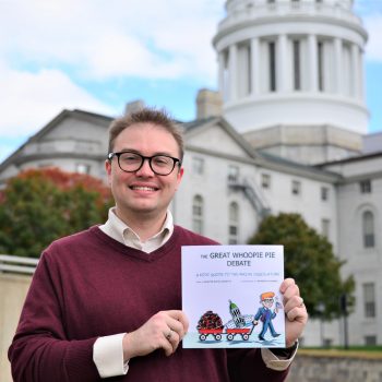 State Senator and UMA Student Justin Chenette holding book he has published.