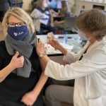 UMA Dental Health Programs Coordinator Nancy Foster, in UMA mask (photographed getting her injection in real time) received her first of two COVID-19 Vaccine.