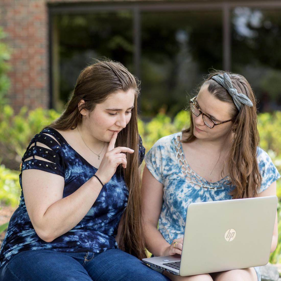 two UMA students study outdoors