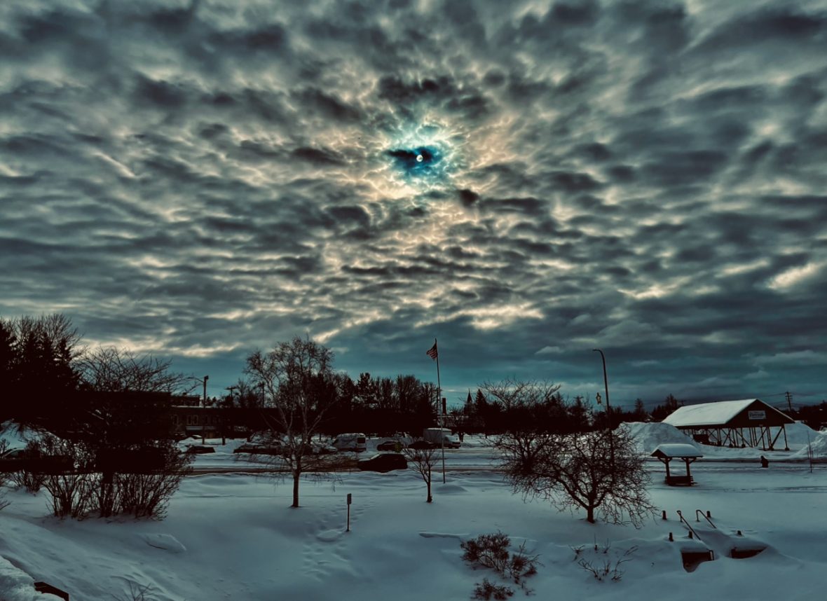 a scenic, blue, white, and brown picture of the sky and clouds over a snowscape