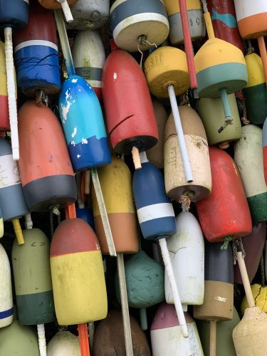 a close-up of a collection of multicolored wooden fishing buoys