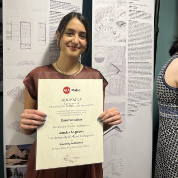 Jessica Angelova, BArch '22, holding her award certificate in front of a poster showing the award winning project