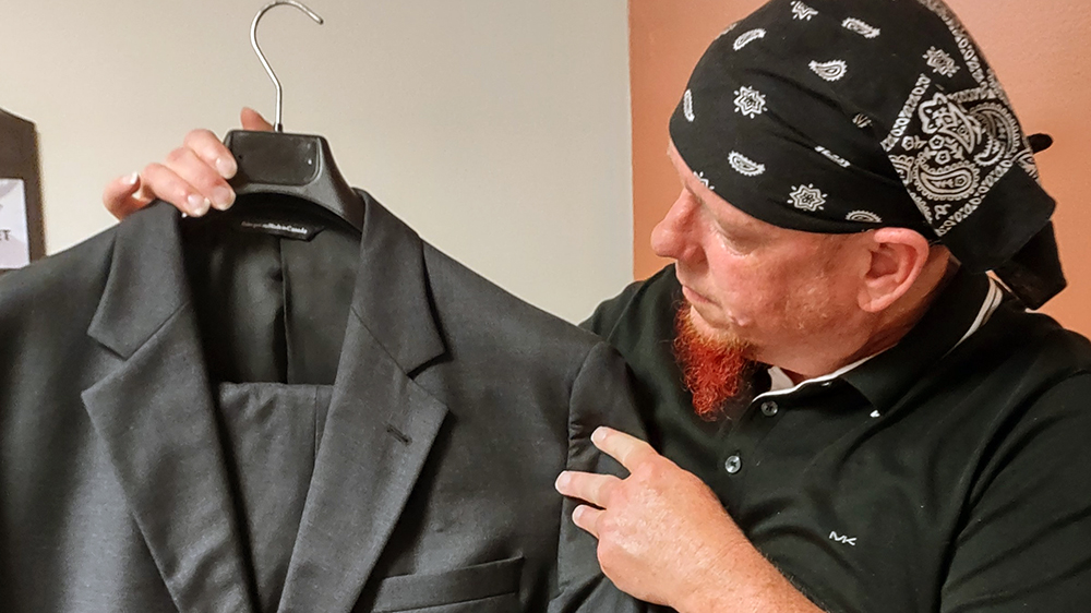 Student with sample of suit from professional clothing closet