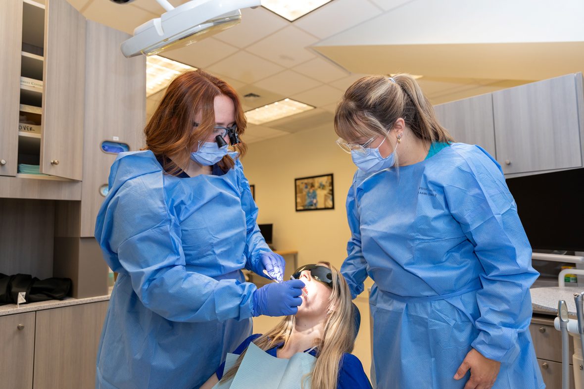 UMA dental students work with program coordinator at the Lewiston dental clinic.