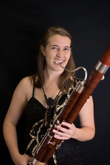 Lindsey Wiehl smiles joyously while holding her bassoon