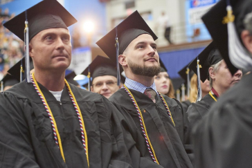 Graduates proudly wear red, white, and blue honor cords recognizing their military service during the University of Maine at Augusta’s commencement ceremony.