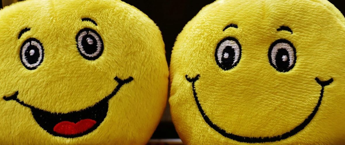 Two plushy smiley-face emoji characters
