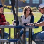 UMA students gathered at a table talking socially