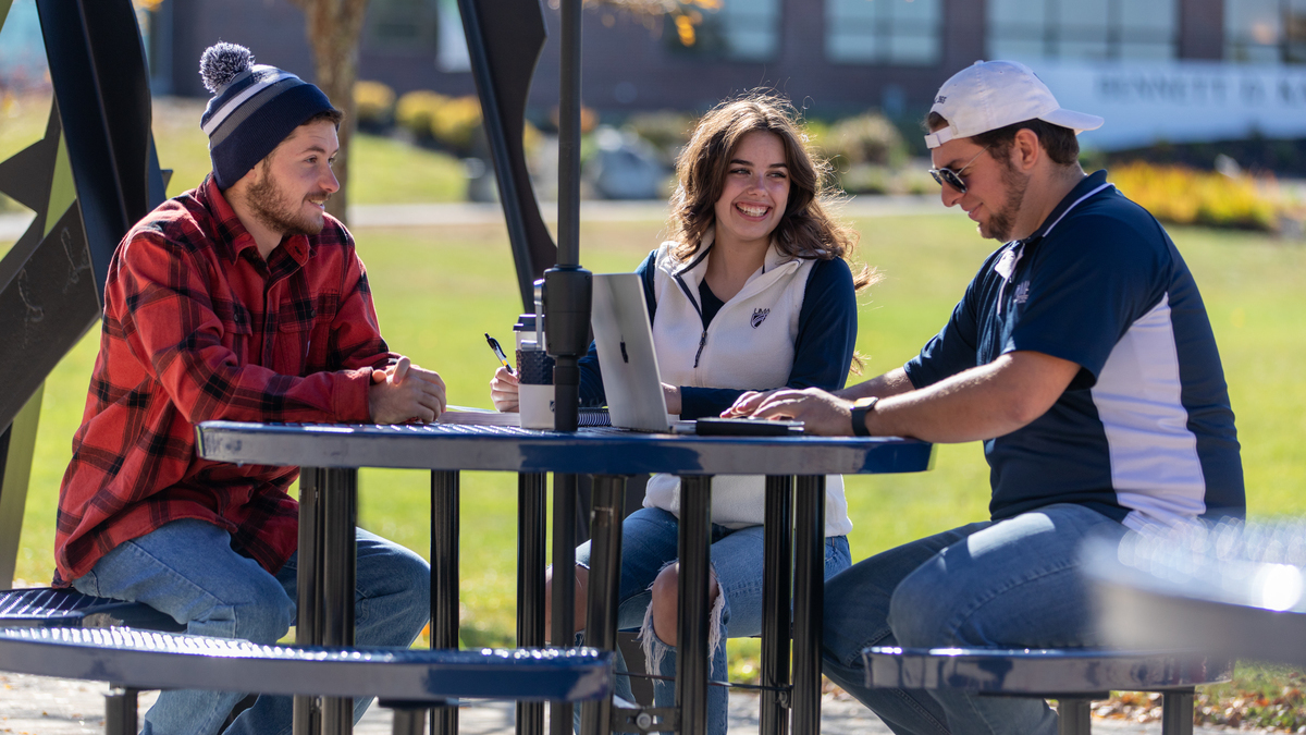 UMA students gathered at a table talking socially