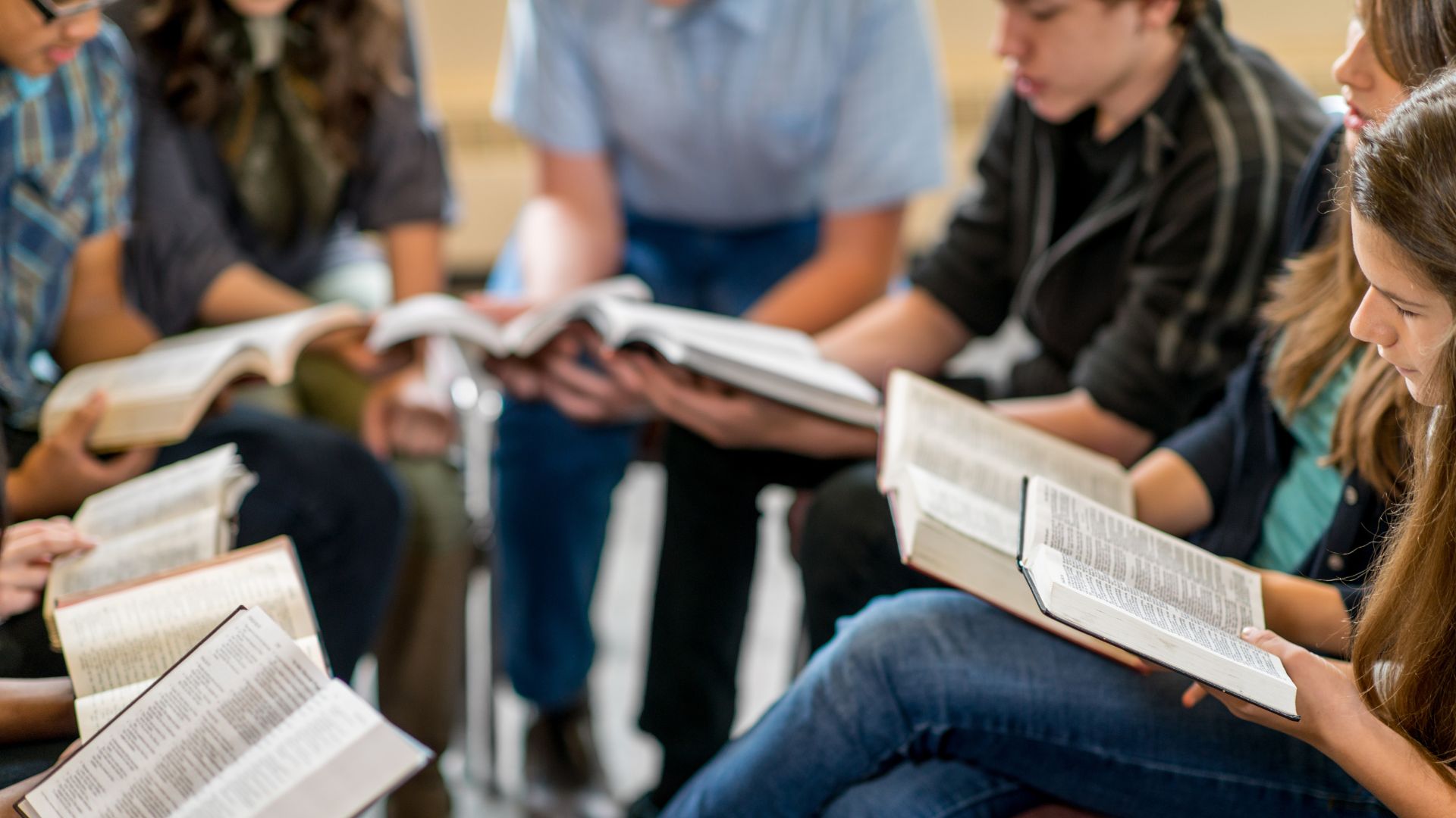 People sitting in a circle , each with their own book, in deep discussion