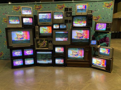 A sculpture collection of cabinet and box televisions with vibrant colors on the screens
