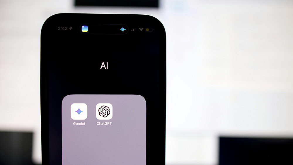 A smartphone screen shows a folder labeled “AI” containing the Gemini and ChatGPT app icons, with a blurred computer screen in the background.