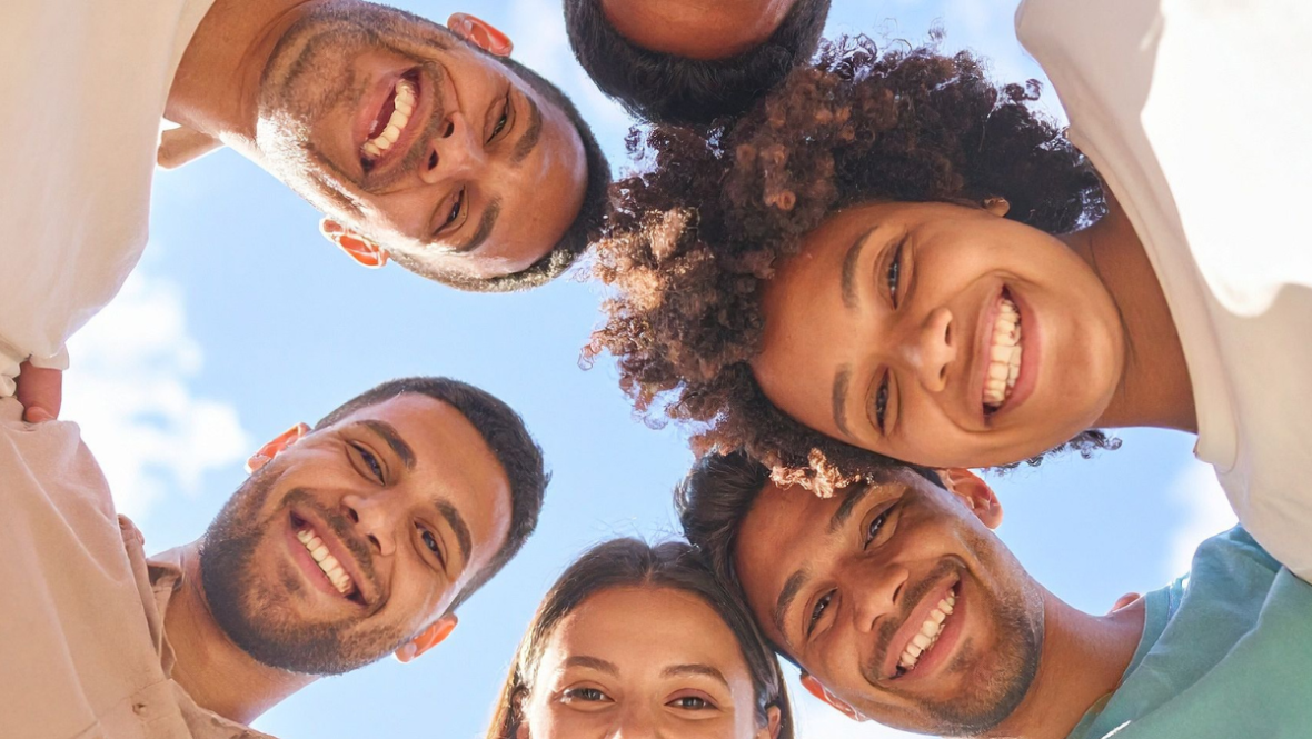 friends huddling around and smiling at the camera