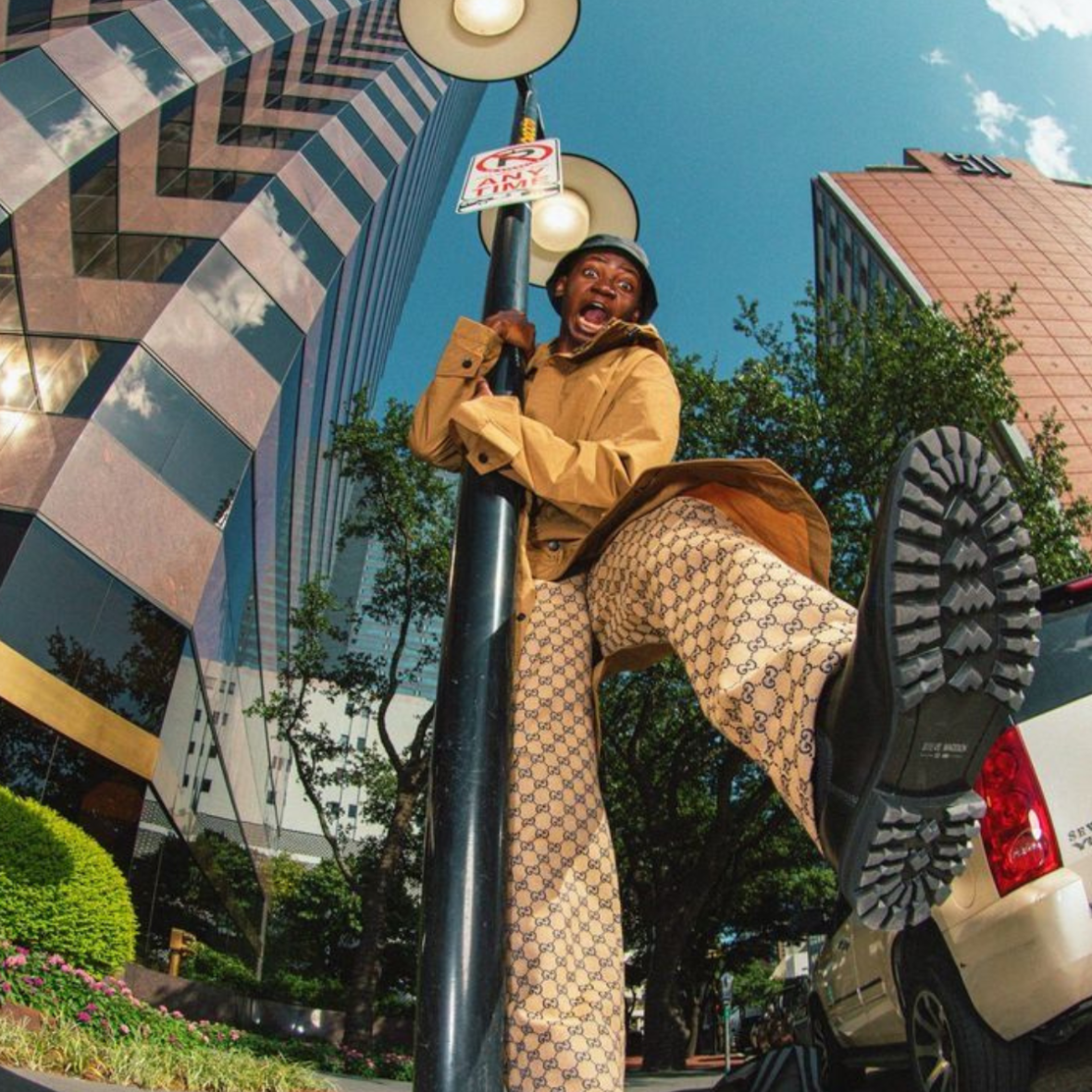 a person holding onto a street light pole