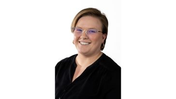 portrait of Christine Knight with short hair, glasses and a big smile against a white background