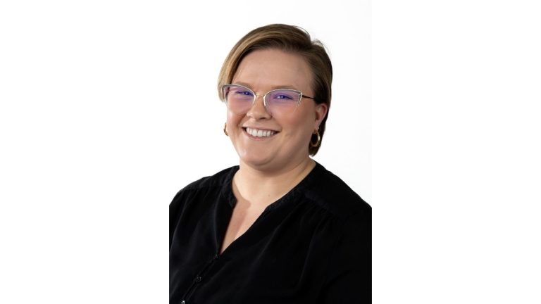 portrait of Christine Knight with short hair, glasses and a big smile against a white background