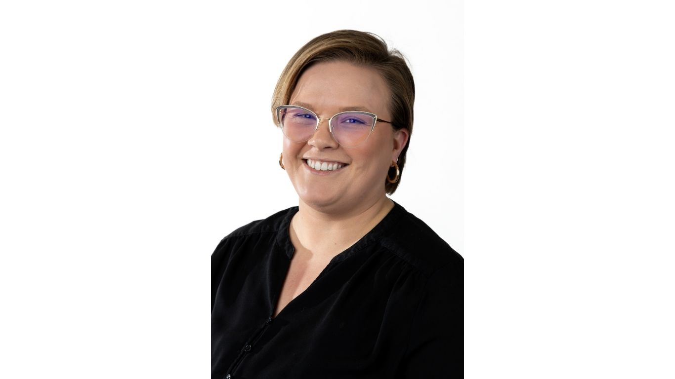 portrait of Christine Knight with short hair, glasses and a big smile against a white background