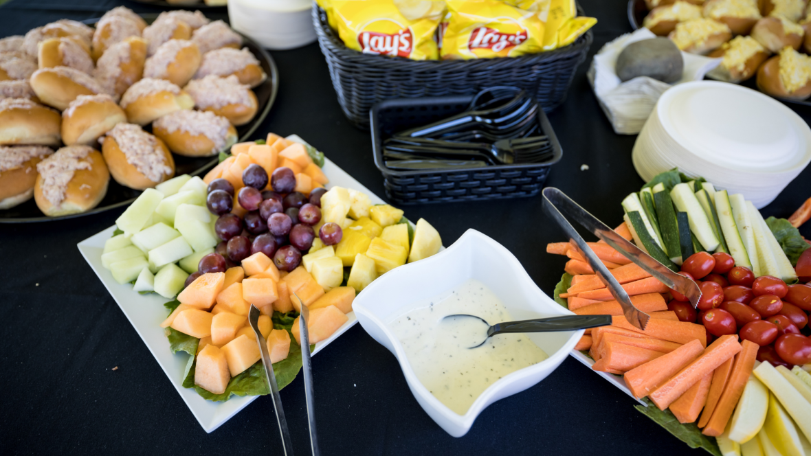 table full of fresh sandwiches, fruits, and veggies.