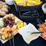 table full of fresh sandwiches, fruits, and veggies.