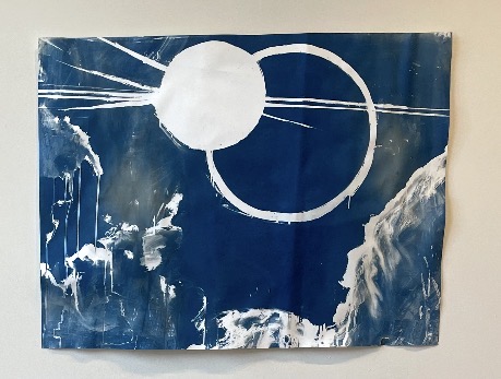 blue and white art piece featuring circles representing the eclipse