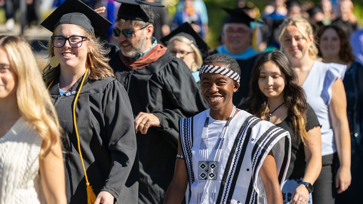 Faculty, staff, and students walk together in the Convocation 2025 procession on a sunny day, celebrating the start of the academic year.