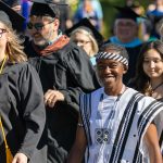Faculty, staff, and students walk together in the Convocation 2025 procession on a sunny day, celebrating the start of the academic year.