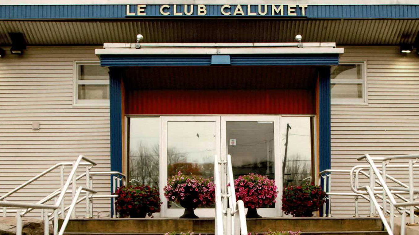 The front doors of Le Club Calumet with potted flowers decorating the stoop.