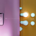 A smartphone with a power button icon on its screen sits on a pink background, visually connected by dotted lines to smart home devices on a yellow background, including light bulbs, round sensors, and a security camera, illustrating phone-controlled home automation.