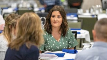 Student sitting at a table with other guests