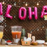 A table with refreshments, with balloons spelling out "ALOHA"
