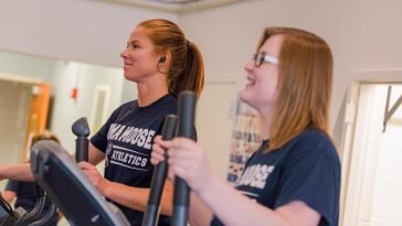 2 UMA students utilizing the running machines in the Bangor fitness center