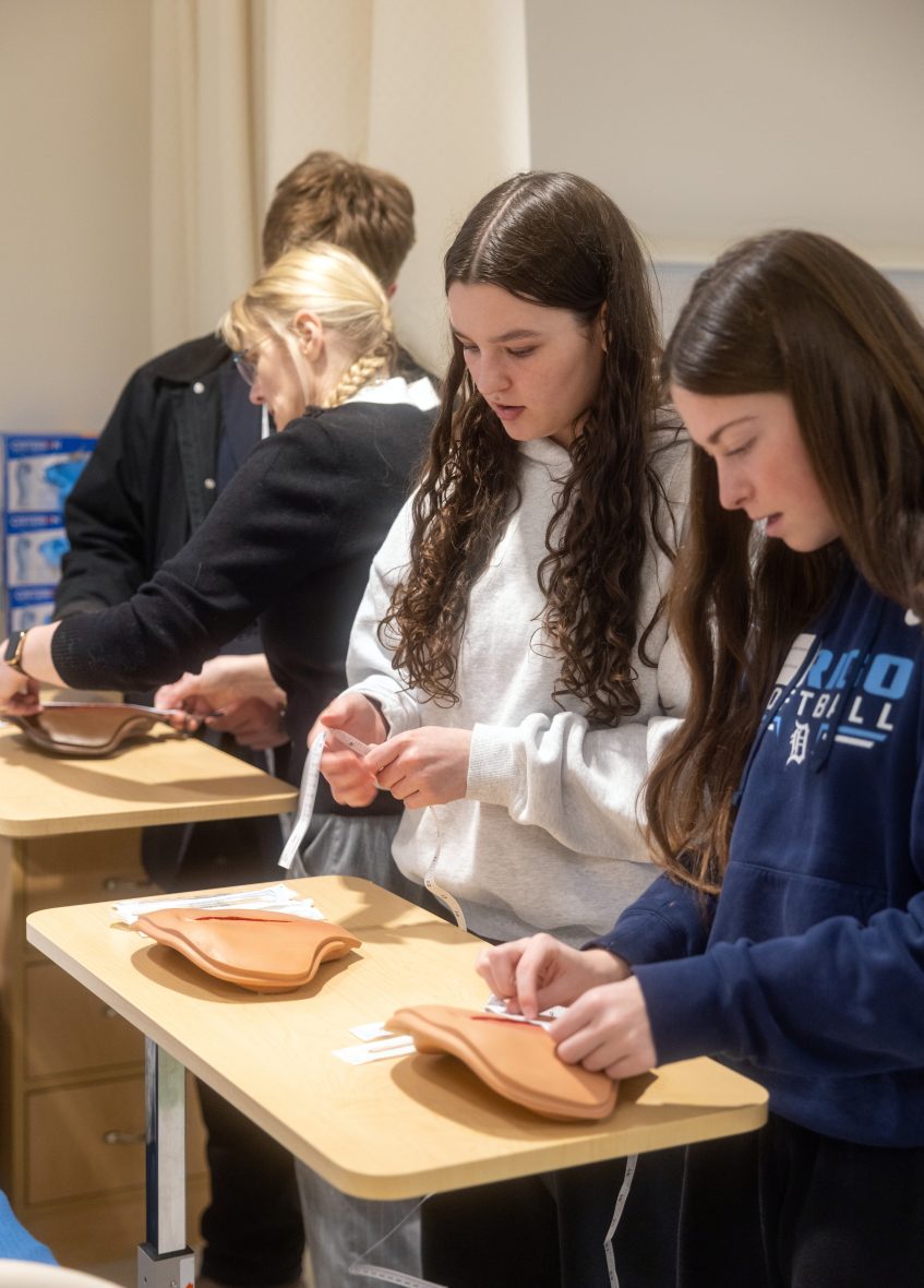 High school students practice wound care techniques on training models during UMA’s Medical Bootcamp.