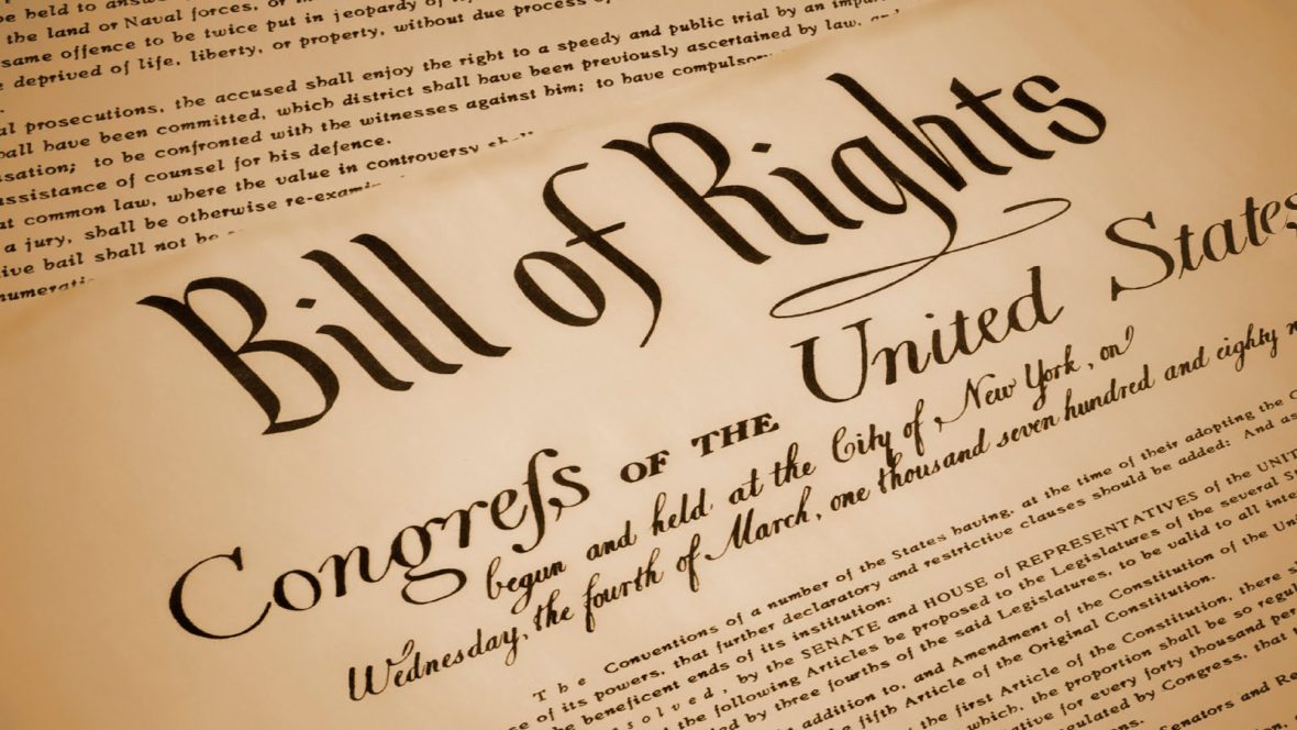Close-up image of the Bill of Rights document, featuring large decorative lettering and portions of the handwritten text of the United States Constitution and amendments.